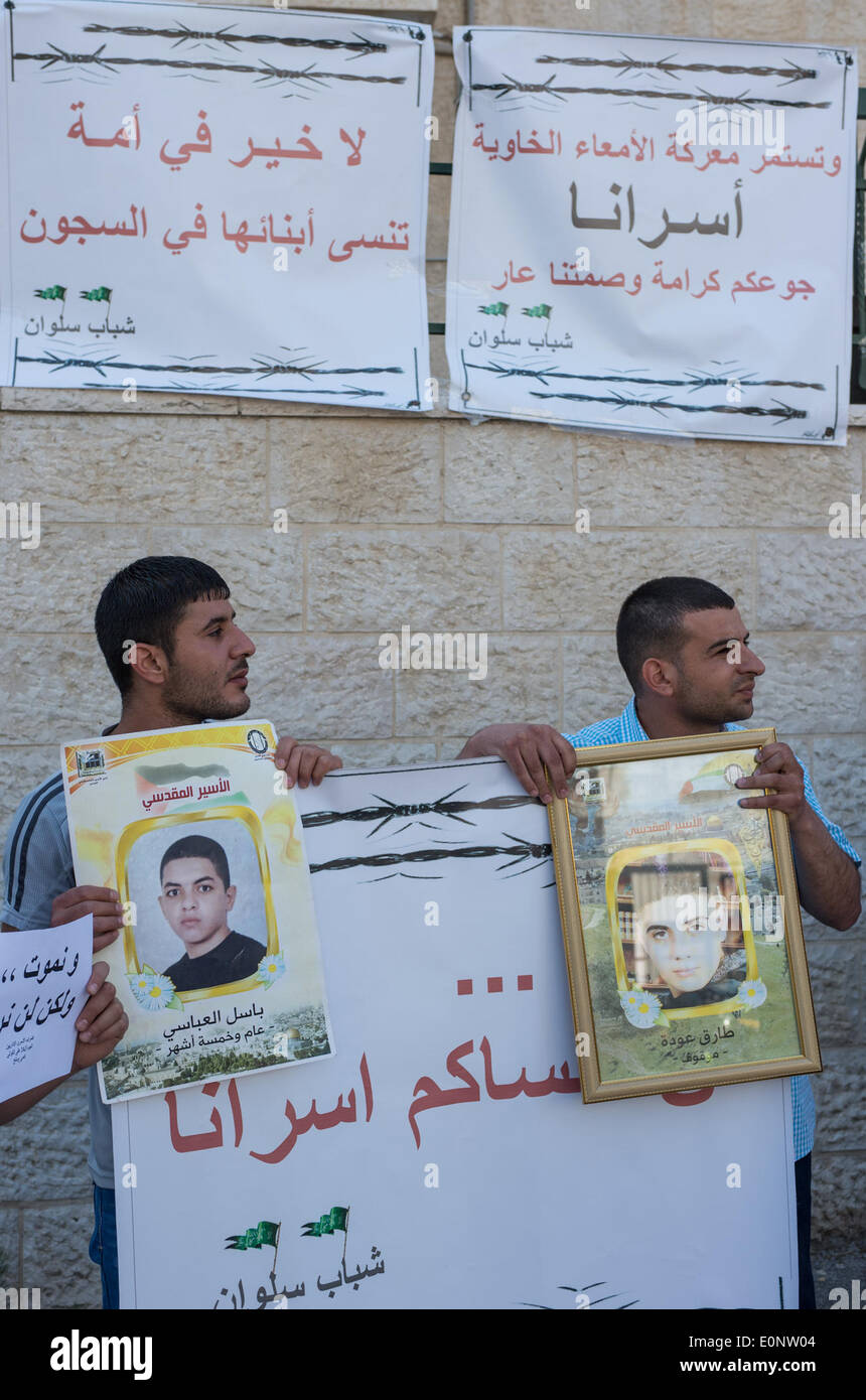 (140517) -- Jérusalem, le 17 mai 2014 (Xinhua) -- les manifestants tenir photos de prisonniers palestiniens dans les prisons israéliennes au cours d'une protestation contre la détention administrative d'Israël politiques devant le bâtiment de la Fondation de la Croix Rouge à Sheikh Jarrah, Jérusalem, le 17 mai 2014. Plus de 50 manifestants, dont la plupart sont des parents ou amis des prisonniers palestiniens dans les prisons israéliennes, a pris part au rallye ici le samedi. La détention administrative est une politique qui permet à Israël de conserver les Palestiniens en prison pour des périodes de six mois renouvelables sans procès. Selon Ministère palestinien de priso Banque D'Images