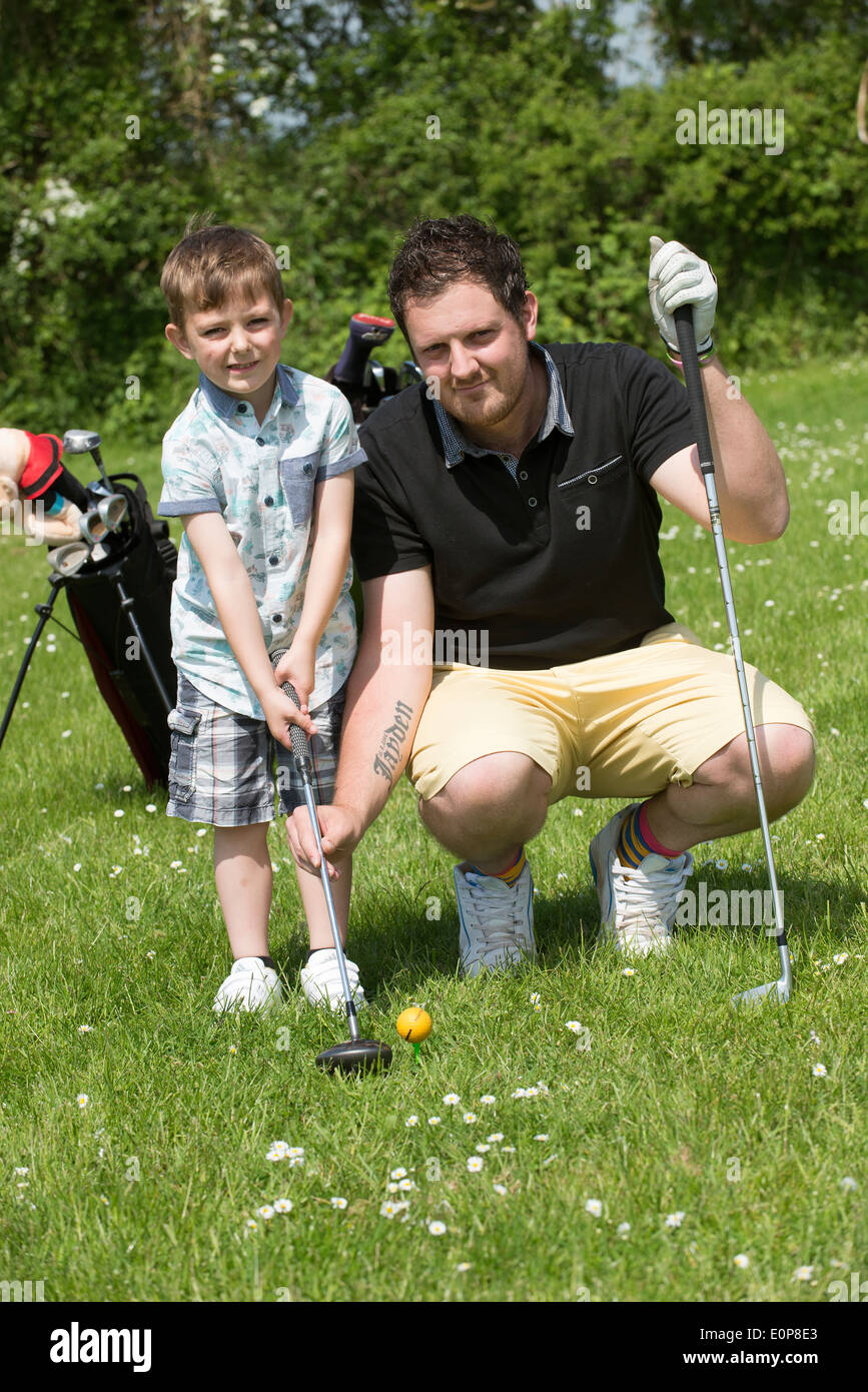 À l'âge de cinq ans, garçon de prendre leçon de golf avec son père Hampshire England UK Banque D'Images