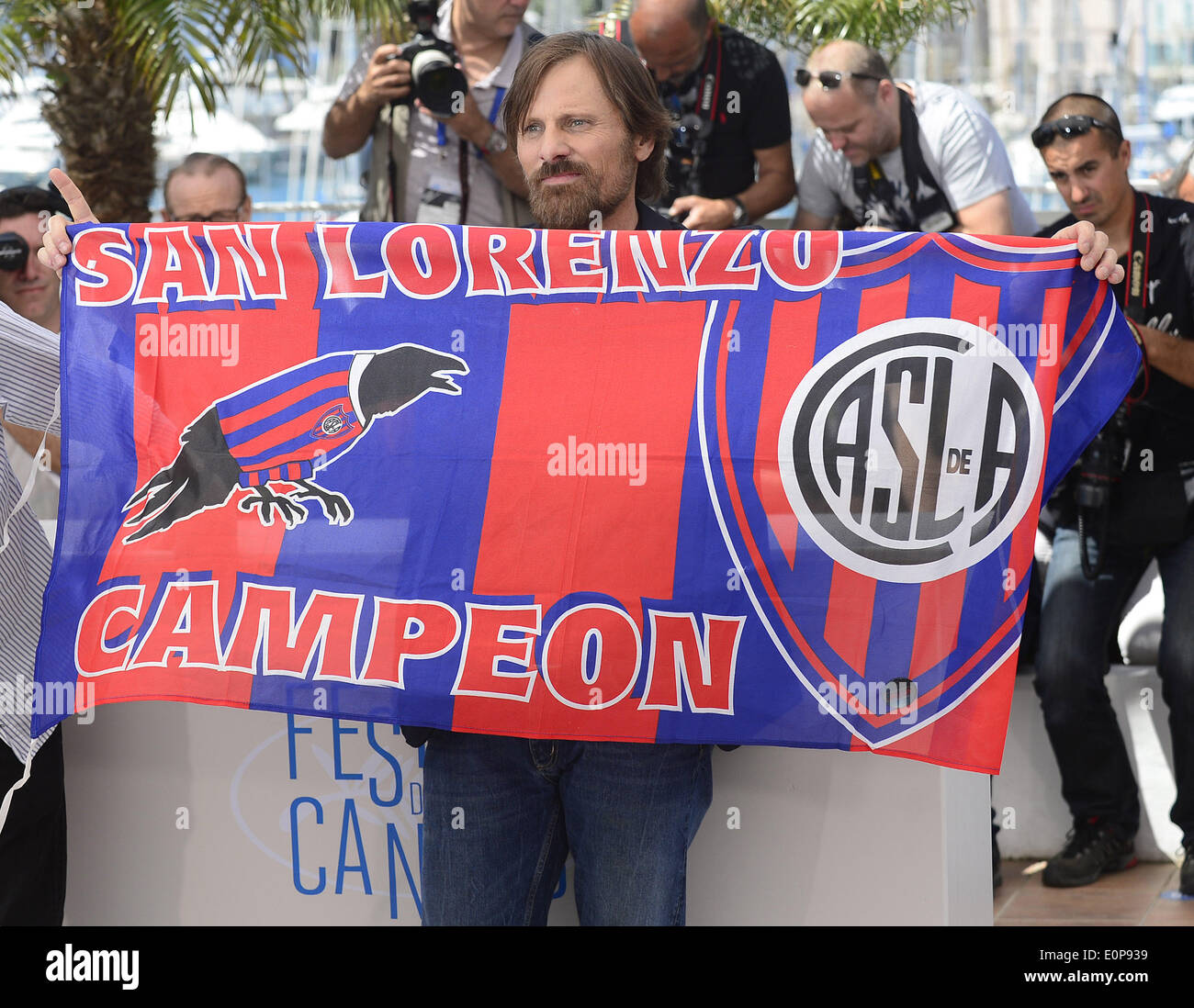 Cannes, France. 18 mai, 2014. Les danois Viggo Mortensen acteur américain tient le drapeau de la San Lorenzo de Almagro football club lors d'une séance de photos pour le 'Jauja' à la 67ème Festival du Film de Cannes, France, le 18 mai 2014. Le film est présenté dans la section Un Certain Regard du Festival qui aura lieu du 14 au 25 mai. Credit : Ye Pingfan/Xinhua/Alamy Live News Banque D'Images