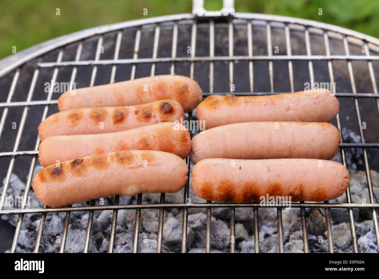 Saucisses grillées sur un barbecue en plein air de pique-nique Banque D'Images