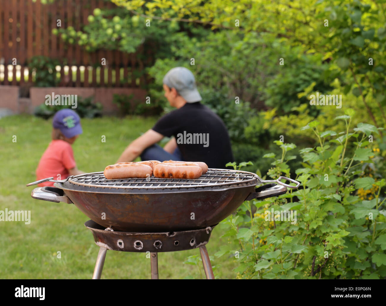 Saucisses grillées sur un barbecue en plein air de pique-nique Banque D'Images