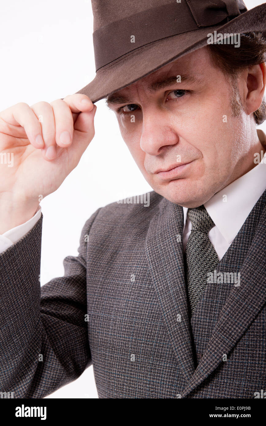 L'homme en costume gris avec sa main sur son chapeau sur un fond blanc, Banque D'Images