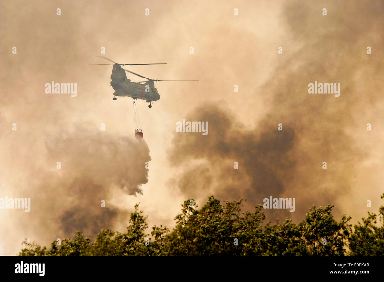 Un hélicoptère de l'US Marine Corps transporte l'eau dans un seau Bambi pour aider à combattre le tomahawk et Las Pulgas friches comme ils brûlent les contreforts 16 Mai 2014 autour de Camp Pendleton, en Californie. Plus de 13 000 évacuations forcées des personnes à leur domicile comme le feu a brûlé dans le comté de San Diego. Banque D'Images