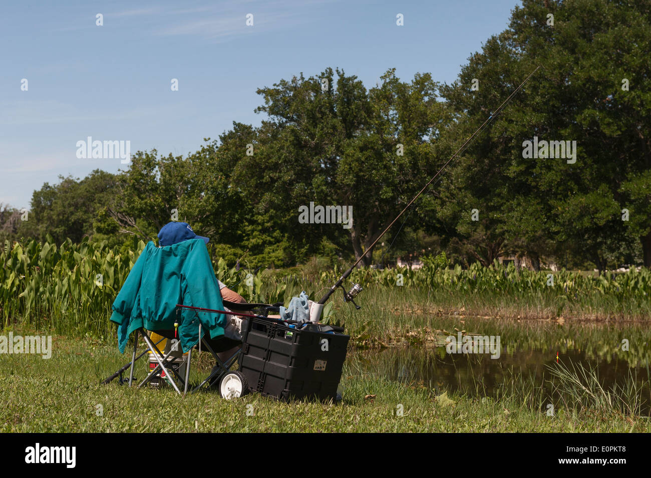 Homme portant la retraite chapeau et assis dans sa chaise en pêche sportive creek situé à Leesburg, en Floride Banque D'Images