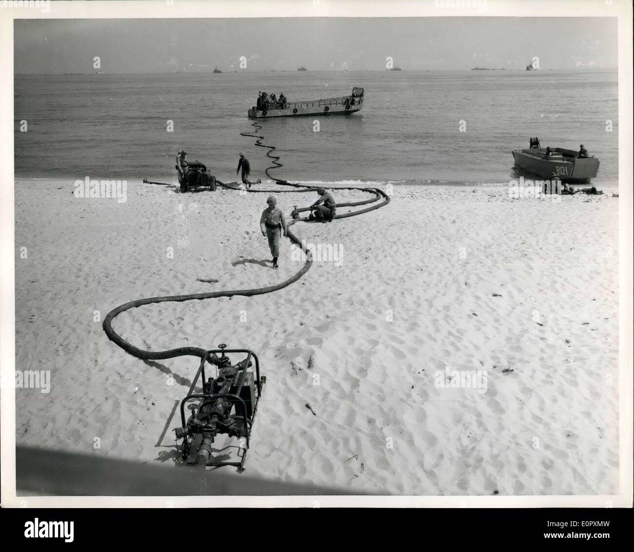 24 avril 1957 - Marine Corps de carburant en vrac : système amphibie de la marine UN LCVP permet de brancher les conduites de carburant soutenue à une station de déchargement de vrac beach, permettant un flux constant de l'essence d'un navire se trouvant à la station. Banque D'Images