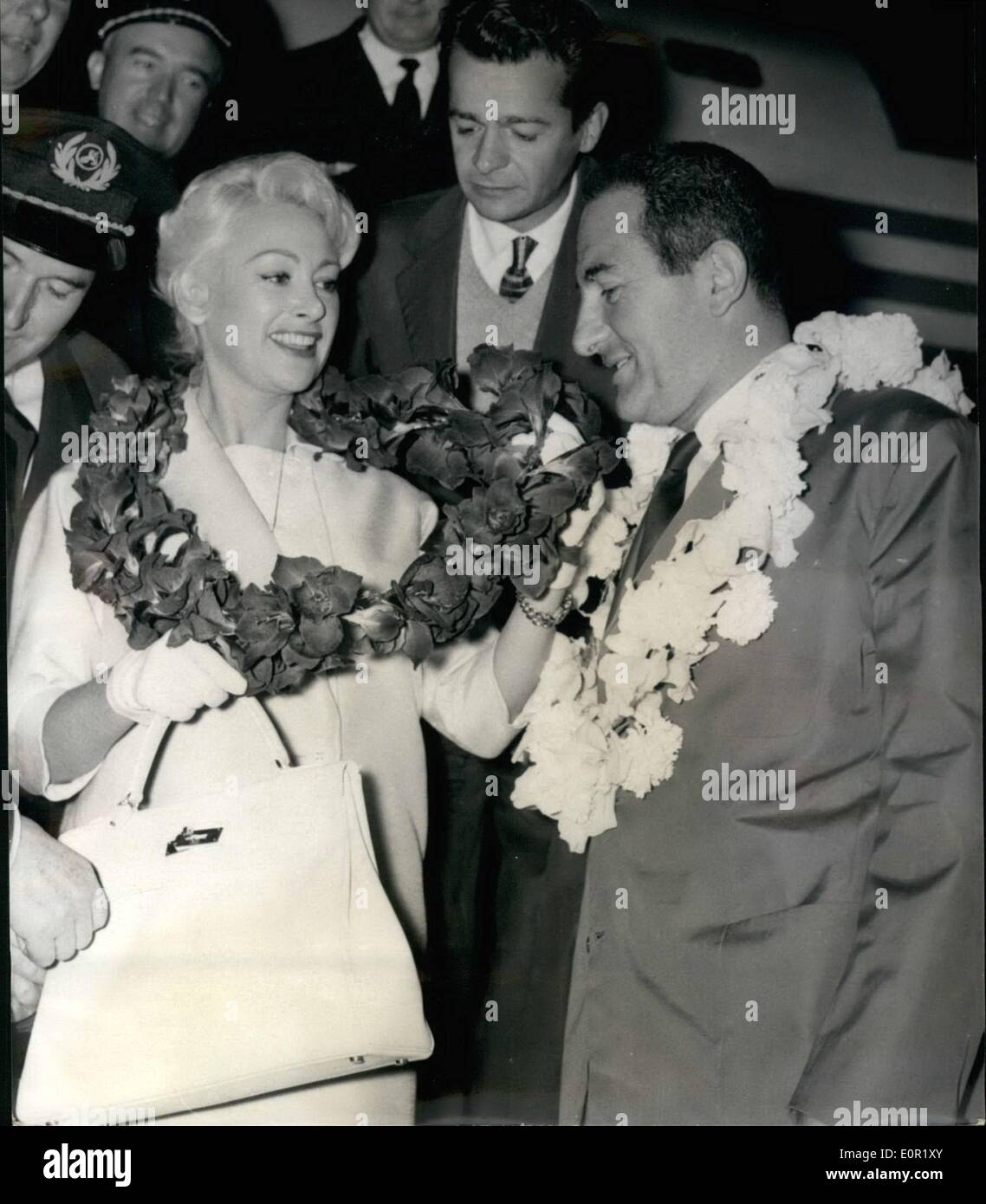 Septembre 09, 1957 - Martine Carol Off à Tahiti : Martine Carol, la célèbre star de l'écran, quitte Paris pour Tahiti ce matin. Martine est en vedette dans un nouveau film ''Passager clandestin'' (le passager clandestin) basé sur l'histoire de Siméon, une partie sera faite à Tahiti, Photo, Martine Carol et le producteur Ralph Habib portant la couronne de fleurs traditionnelles avant de monter dans l'avion ce matin. Serge Regian, l'acteur de cinéma, se voit dans l'arrière-plan. Banque D'Images