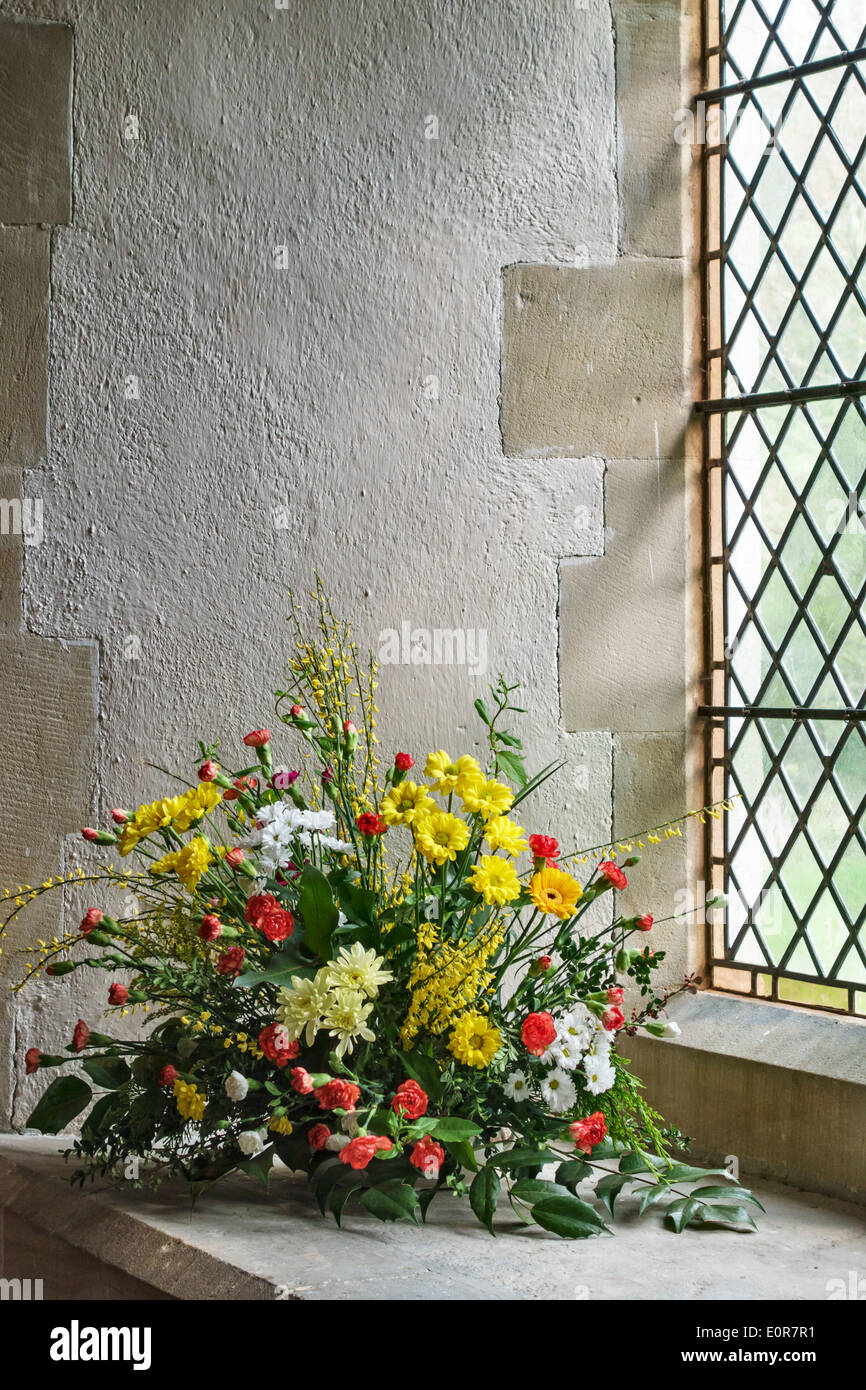 Un arrangement de fleur de printemps dans la fenêtre d'une église médiévale, Royaume-Uni Banque D'Images