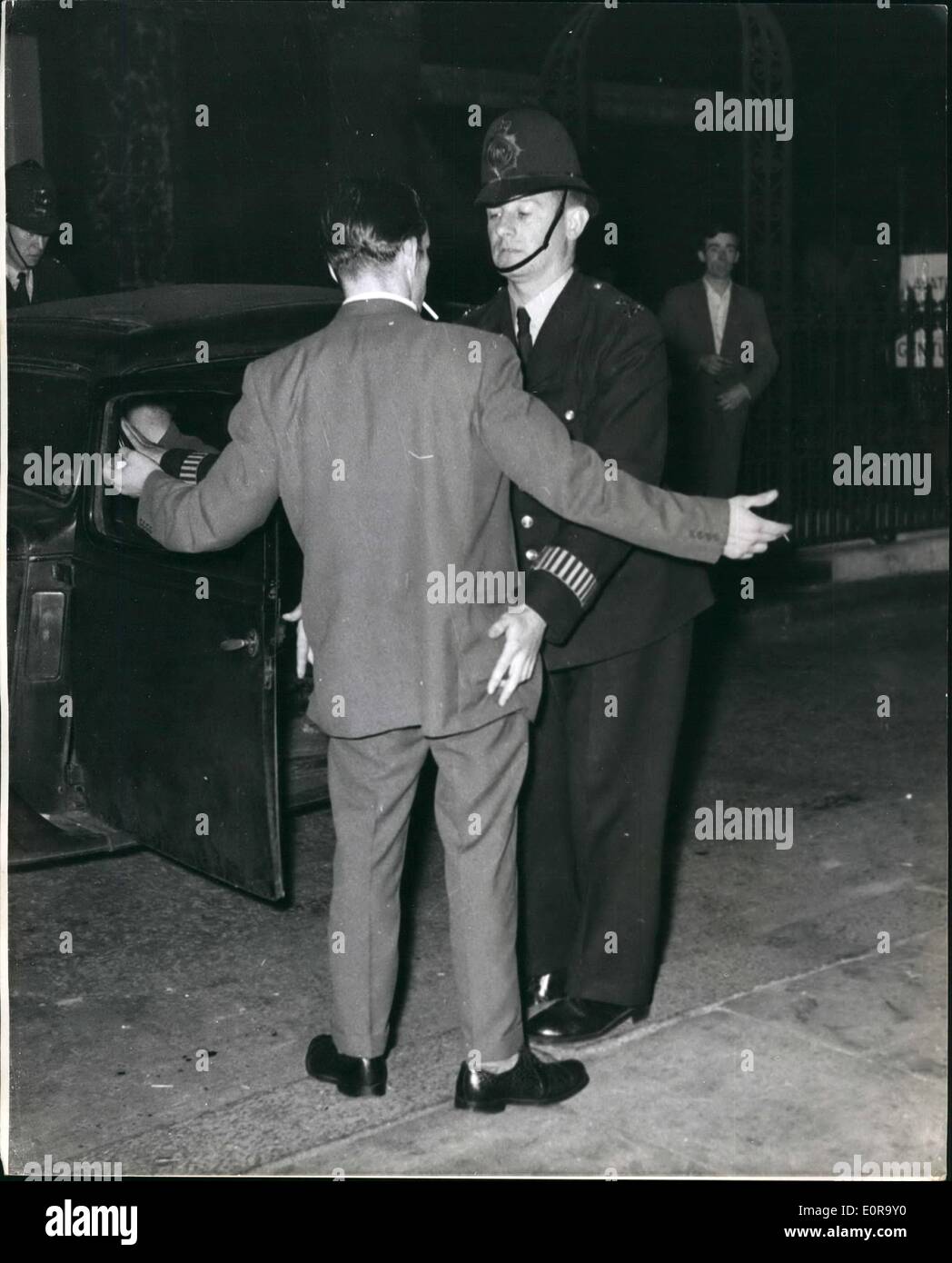 Septembre 09, 1958 - émeutes Black-White une fois encore dans Notting Hill Gate.. Policier ''Fouille'' un homme blanc de nombreuses arrestations ont été effectuées lorsque les blancs et les noirs se sont affrontés une fois de plus - dans la région de Notting Hill de Londres. C'était la quatrième nuit à la suite de ces émeutes dans la région.. Photo Keystone montre :- un policier 'fouille' un Whiteman - comme les émeutes ont été démembrées - à Blenheim Crescent, Notting Hill Gate. Banque D'Images