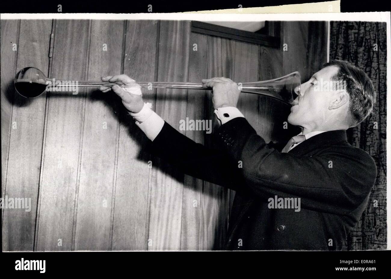 Septembre 11, 1958 - UN Docker prend du temps de déchargement des bateaux pour ouvrir des dockers d'East End Pub. Aujourd'hui, 45 ans, docker George Denton, a pris le temps de déchargement des bateaux dans Victoria Docks d'ouvrir une nouvelle maison, le ''nouveau Gog'' dans la feuille de route du franc-maçon, dans l'East End. Il l'a fait en buvant une "cour de ale', la bière contenue dans un 3ft. de long tube de verre en forme de cor de chasse. George dit qu'il n'a jamais bu d'un avant, mais admet qu'il a eu un peu d'expérience de boire de la bière. Le ''nouveau Gog'' est l'ancien ''Royal Albert'' qui a été complètement détruite par l'ennemi le Jan 13, 1945 Banque D'Images