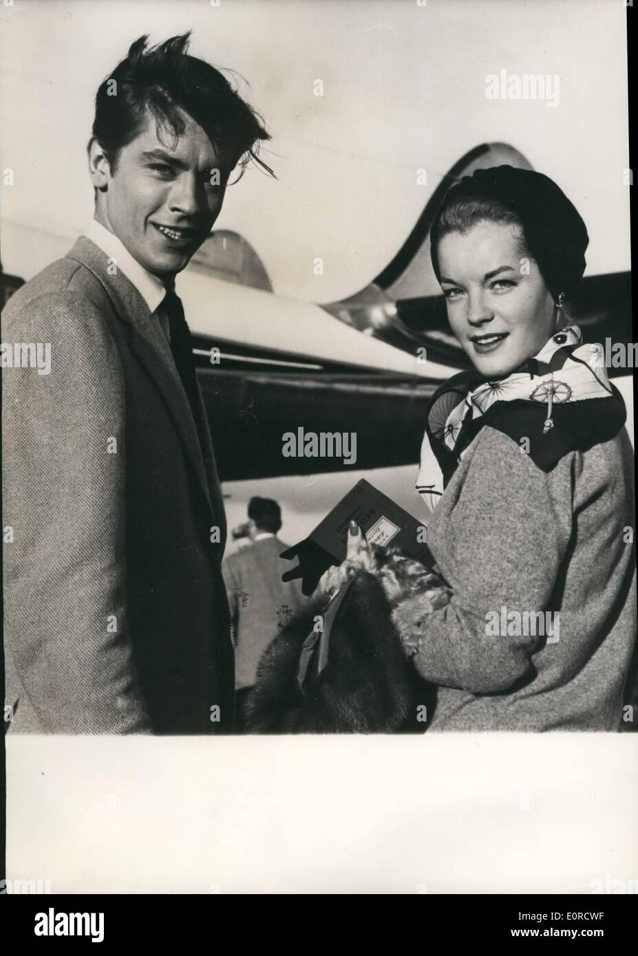 Mar. 03, 1959 - engagé ? Romy Schneider tenant son ''Reisepass" vu à l'aéroport d'Orly quand elle a pris l'avion pour la Suisse. Avec elle est le jeune acteur français Alain Delon. Il est dit que le couple pourrait bientôt annoncer leur engagement. Banque D'Images