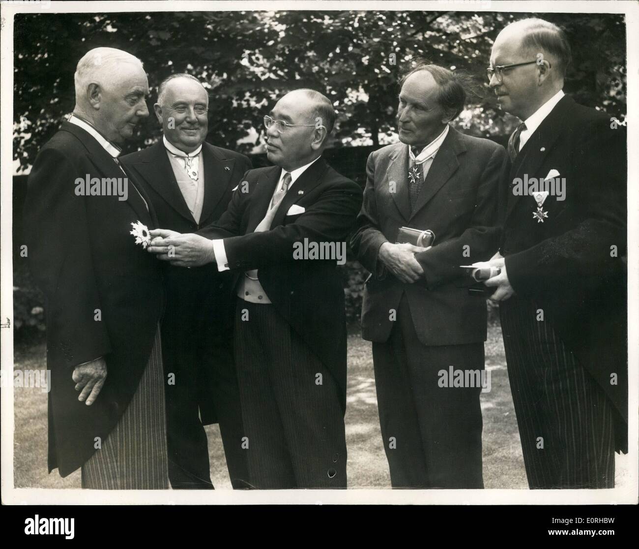 Juillet 23, 1959 - 23-7-59 L'ambassadeur japonais décerne des prix à des Bretons. Cérémonie à l'Ambassade à Londres. M. Katsumi Ohno l'Ambassadeur du Japon à Londres ce matin que lui confère les décorations Japonais sur quatre personnes britanniques à l'Ambassade à Londres. Photo : Keystone montre M. Ohno présente le deuxième ordre de mérite du soleil levant à Sir Norman Roberts (ministre britannique à Tokyo 1950-1952) ; suivi par le colonel George Vente (RDT) qui a reçu le troisième ordre de mérite du Soleil Levant ' M. Arthur Waley qui a reçu le troisième ordre de mérite des trésors sacrés ; et M. Banque D'Images