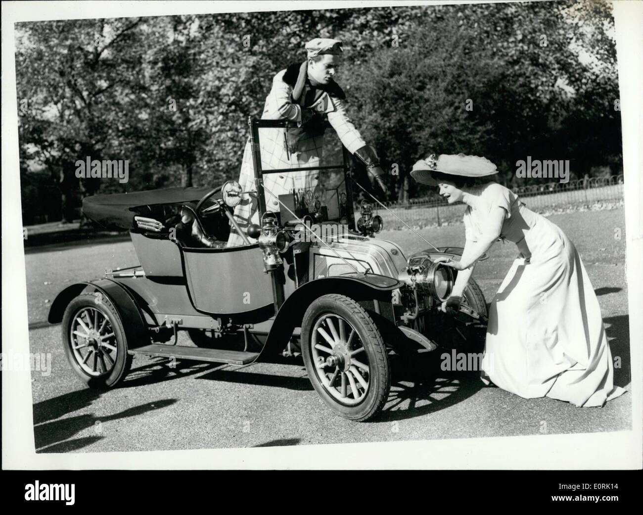 10 octobre 1959 - ''Edwardian'' -sur place à l'automobile : l'actrice Helen Cherry et l'acteur Jeremy Brett qui font leur apparition dans ''The Edwardian'' au théâtre Séville  =- a effectué une visite du salon de l'automobile t aperçu cet après-midi à Earl's Court.. Ils ont été dress-édouardien et voyagé dans une voiture de la période - un 1910. Photo montre Helen Cherry donne un vent sur la poignée de démarrage - avec Jeremy Brett donnant ses instructions de la Renault 1910 dans Hyde Park cet après-midi. Banque D'Images