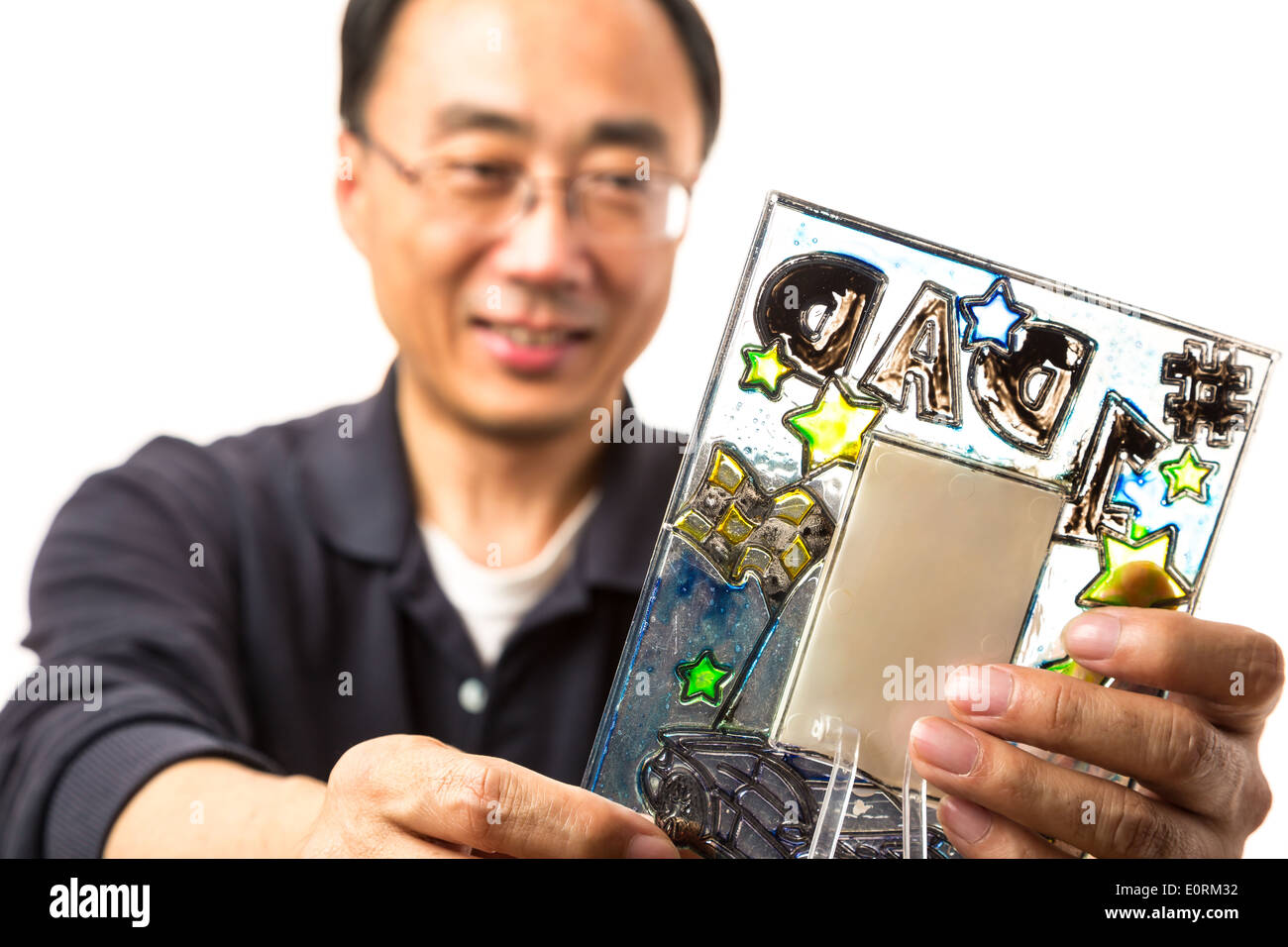 Asian man looking at a picture frame à partir de son fils Banque D'Images