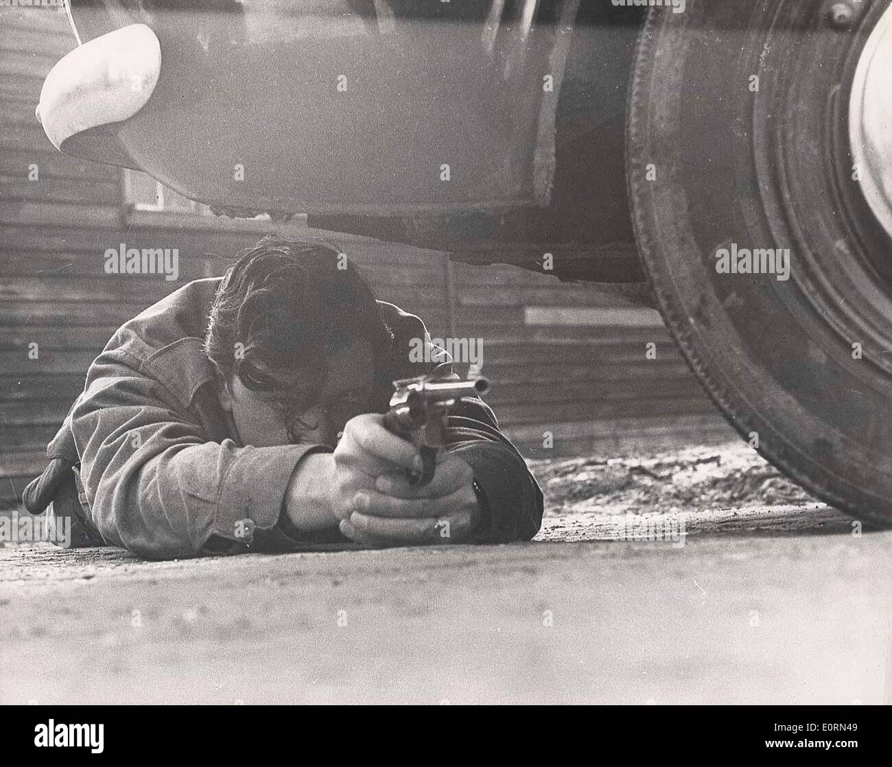Jan 01, 1960 - Essex, Londres, Royaume-Uni, le policier se met à couvert sous une voiture pendant la formation. Date exacte inconnue..(Cred Banque D'Images