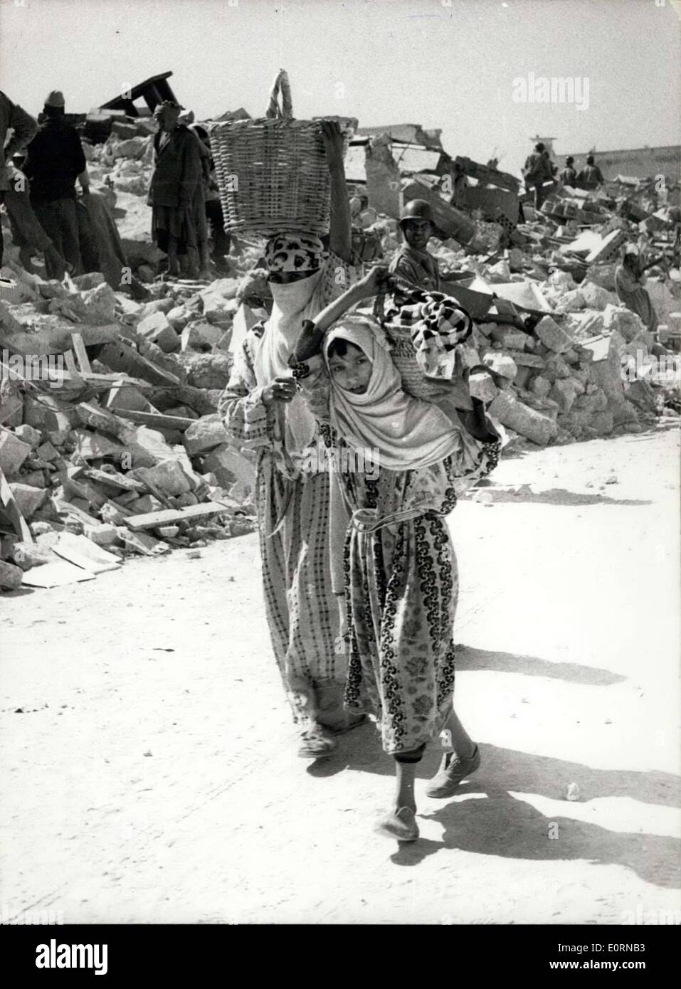 Mar. 04, 1960 - Après le tremblement de terre à Agadir. Ils transportent leurs biens terrestres. Photo montre deux jeunes femmes - avec tout ce qu'ils pouvaient sauver de leurs maisons - vu avec bâtiments détruits derrière - après le earthquakeat Agadir, Maroc., plus de 5 000 chemins permet pour morts. Banque D'Images