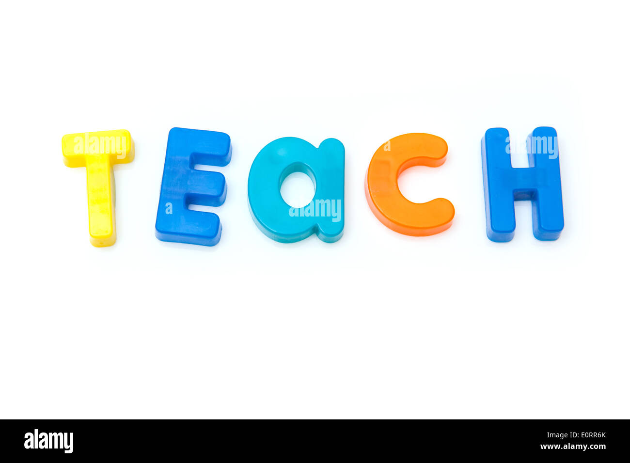 Enseigner l'écrit en lettres magnétique isolé sur un fond blanc studio. Banque D'Images