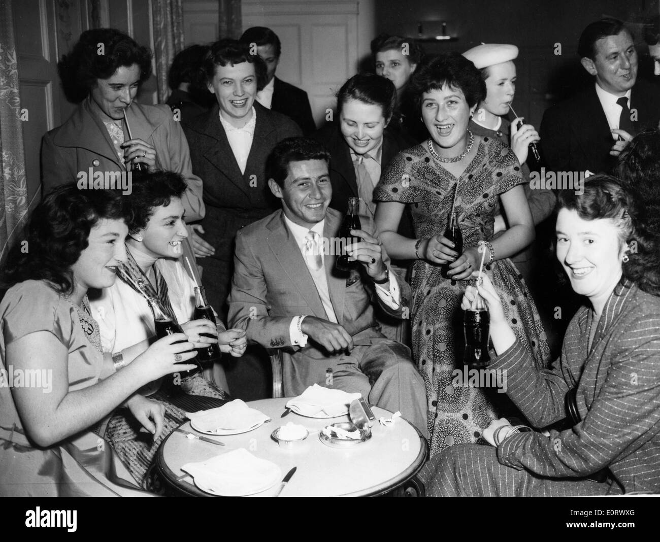 Chanteur Eddie Fisher entouré de femme lors d'une fête Banque D'Images