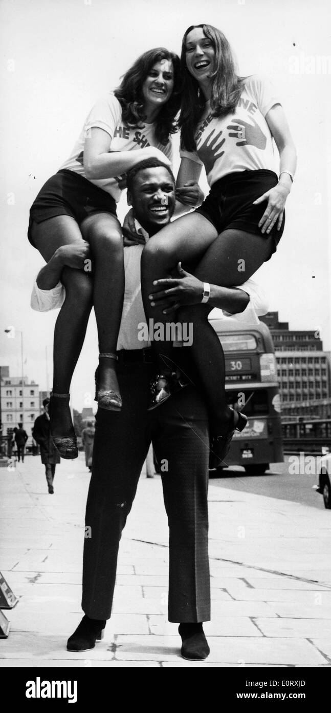 Boxer Smokin' Joe Frazier tenant deux femmes sur ses épaules Banque D'Images