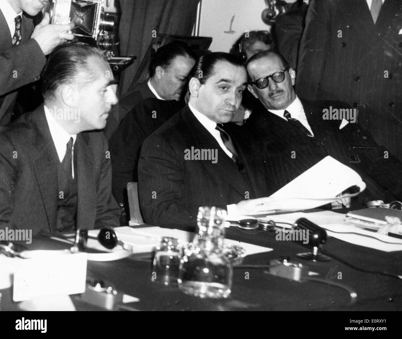 PIERRE MENDES FRANCE, centre, donne sur la paperasse pendant une réunion. Banque D'Images