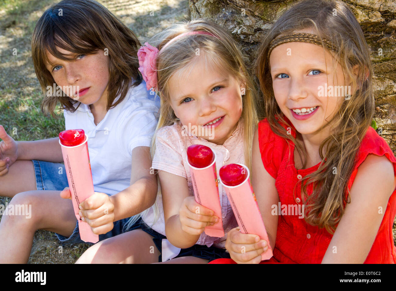 Portrait de jeunes bénéficiant d'ice pop à l'extérieur. Banque D'Images