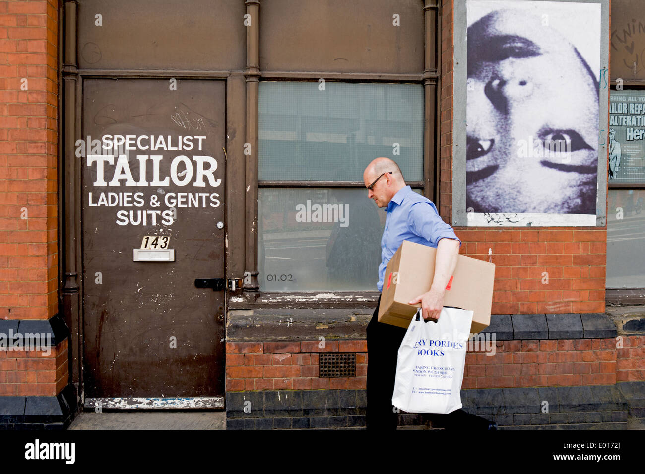 Un homme passe devant une boutique de tailleur à Londres. Banque D'Images