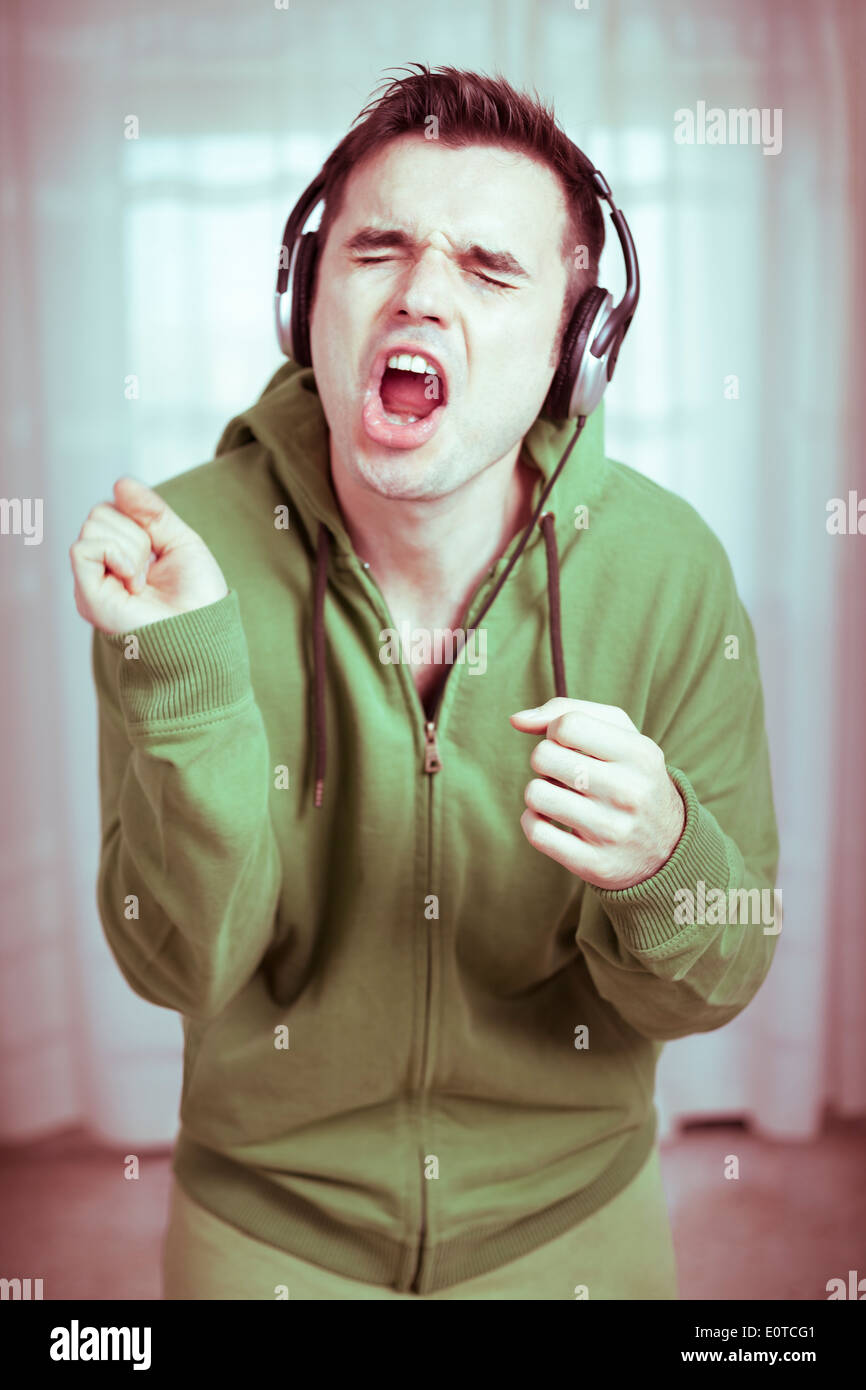 Crazy casual young man with headphones le chant. Banque D'Images