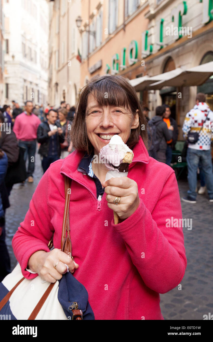 A middle aged woman tourist dans la cinquantaine appréciant et des glaces italiennes, Rome, Italie Europe Banque D'Images