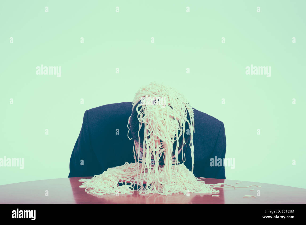 La gourmandise et le consumérisme concept. Greedy businessman eating pasta. Banque D'Images