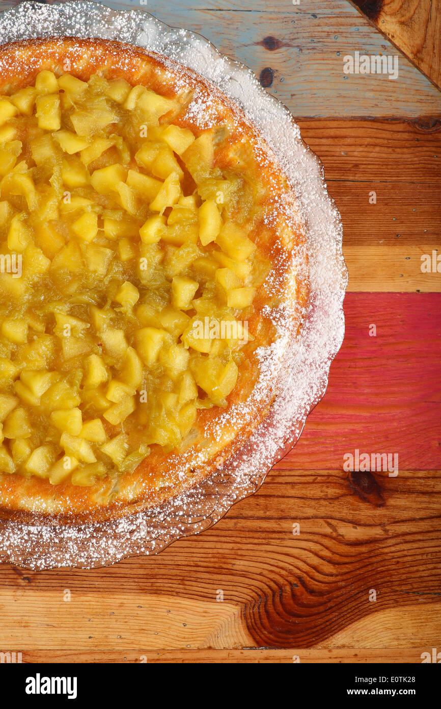 Gâteau sucré à la rhubarbe et les pommes sur la plaque de verre de sucre à glacer, table en bois peint rugueux Banque D'Images