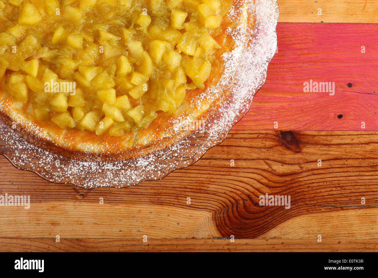Gâteau sucré à la rhubarbe et les pommes sur la plaque de verre de sucre à glacer, table en bois peint rugueux Banque D'Images