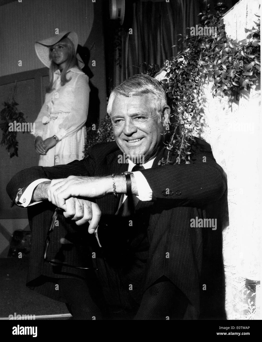 Acteur Cary Grant assis contre un mur Banque D'Images