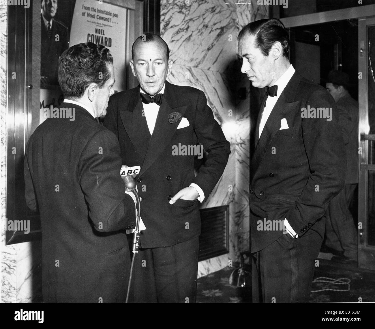 Rex Harrison et Noel Coward sont interviewés at party Banque D'Images