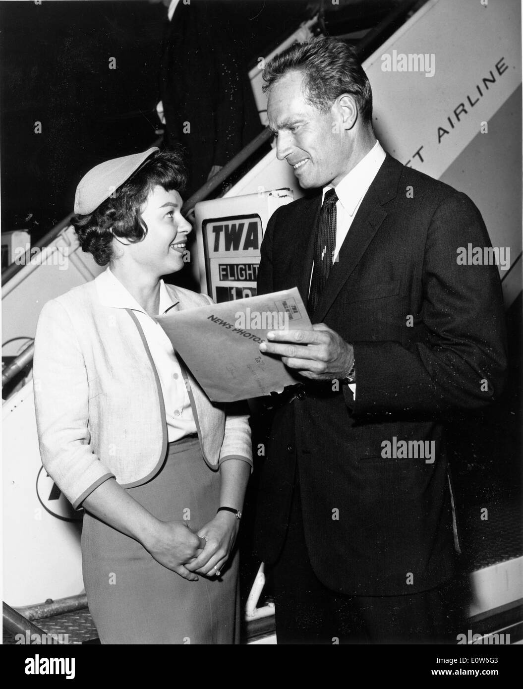 Charlton Heston acteur parlant à TWA Pat hôtesse Selz comme il arrive à New York Banque D'Images