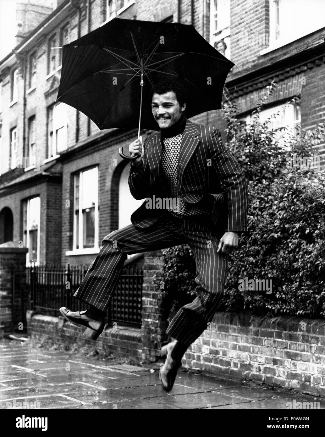 Boxer John Conteh danses dans la pluie sur la rue Banque D'Images