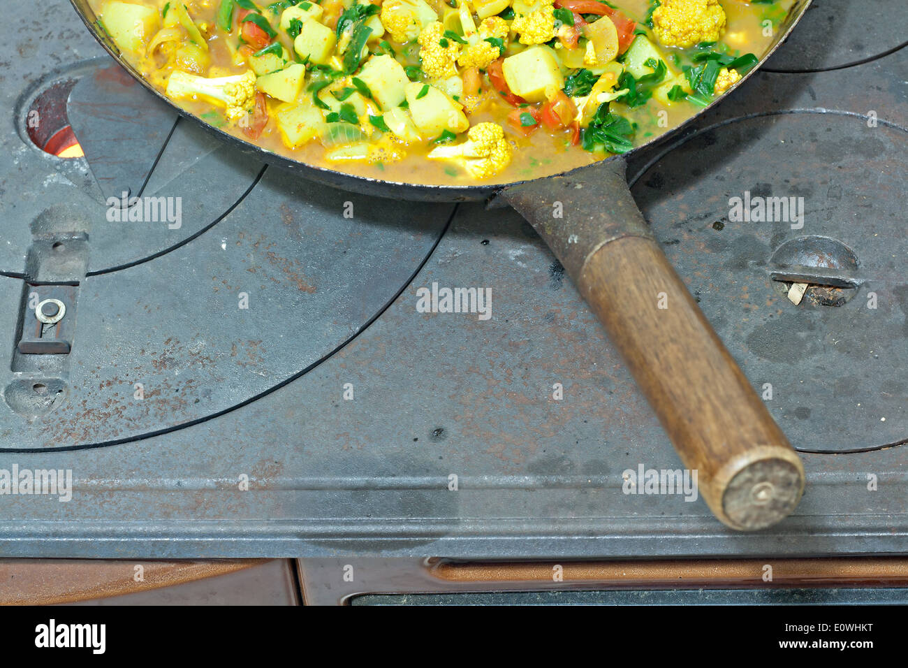 Le légume de cuisson sur la combustion du charbon/bois four en fonte Banque D'Images