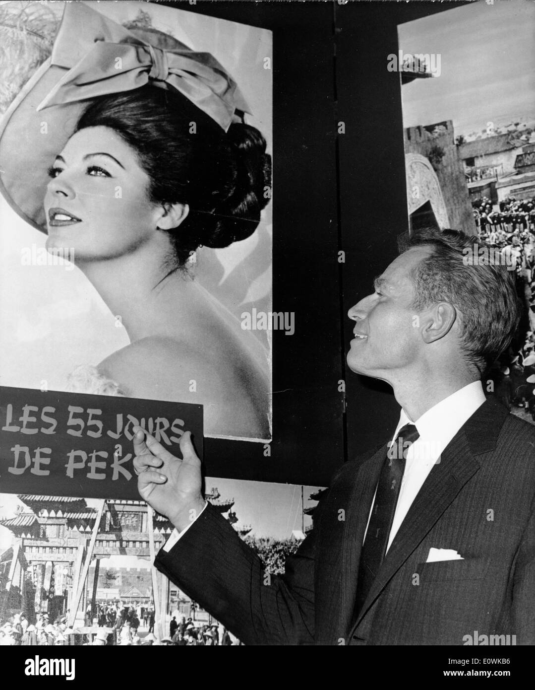 L'acteur Charlton Heston en regardant une affiche pour "55 jours de Pékin" Banque D'Images