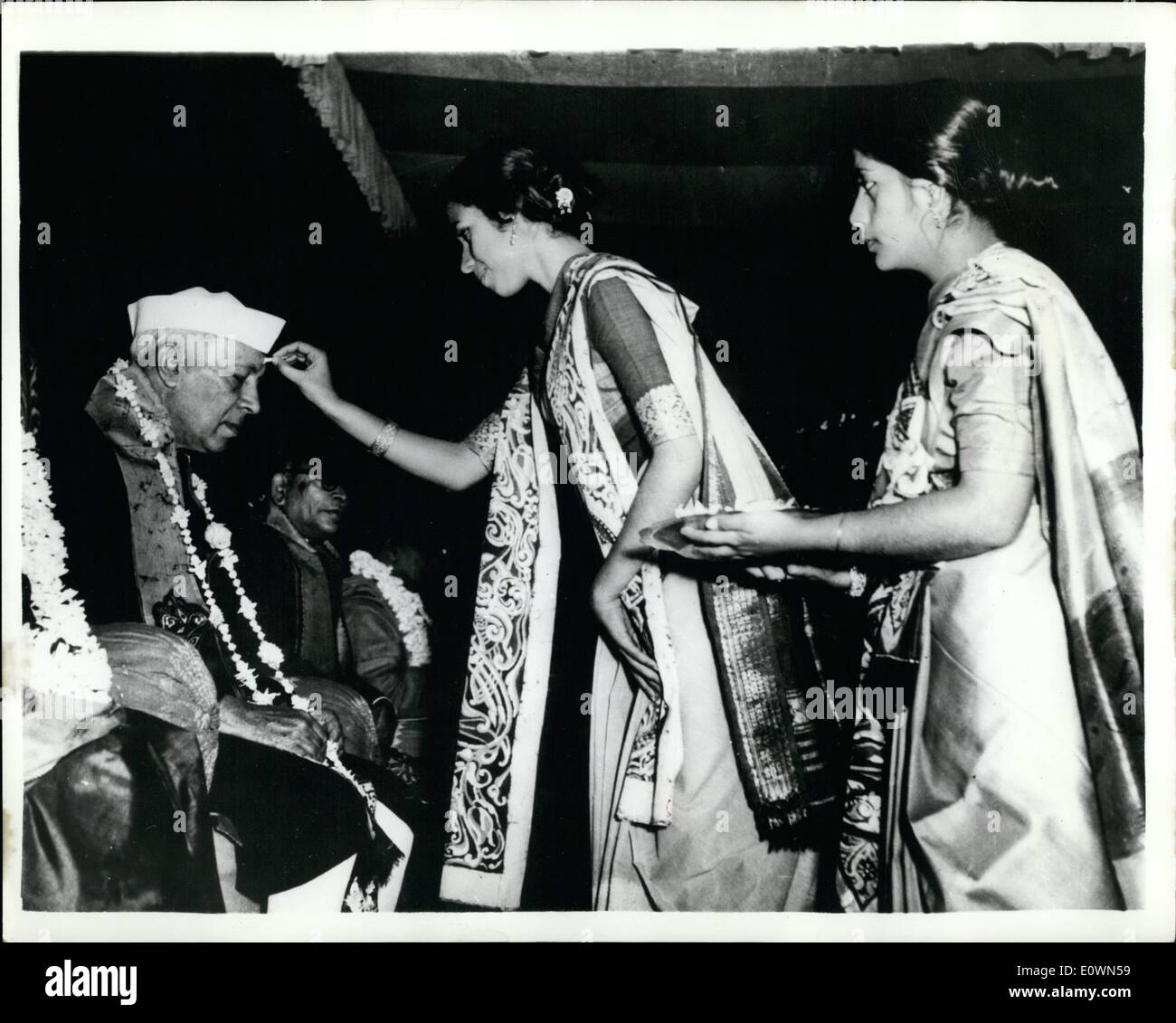 12 déc., 1963 - M. Nehru à l'occasion de la cérémonie, M. Nehru, qui est chancelier, ont assisté à la remise des diplômes à l'Université de Visva-Bharati (Santiniketan), où il a présenté des degrés aux étudiants. Photo montre les filles bienvenue à M. Nehru en mettant un Tilak Chandan sandal (passé) sur son front. Banque D'Images