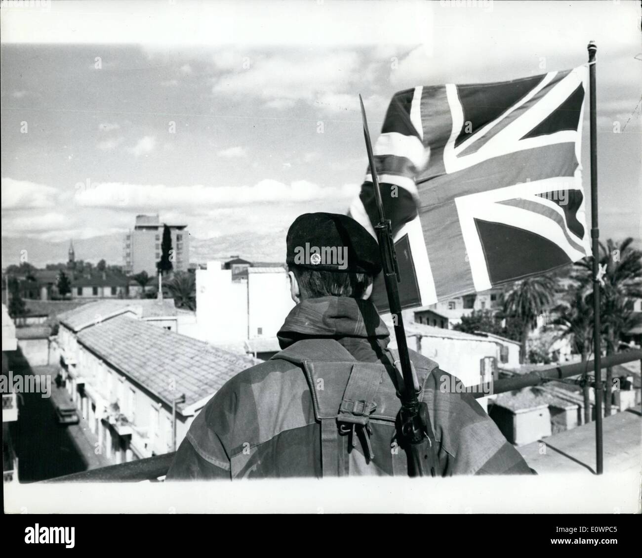 01 janv., 1964 - Retour à la normale de Nicosie à Chypre : La vie à Nicosie, la capitale de Chypre est de retour à la normale après la récente flambée de trouble.Le maintien de la paix les troupes britanniques ont pris des positions plus[auparavant détenus par les Grecs et Turcs, et sont en commandement du général Young qui a établi son Q.G. de la près de la frontière entre le secteur grec et turc.Photo montre un soldat britannique près d'un Union Jack donne d'un grand bâtiment situé sur la ''Mason Dixon'' ligne séparant le secteur grec et turc de Nicosie. Banque D'Images