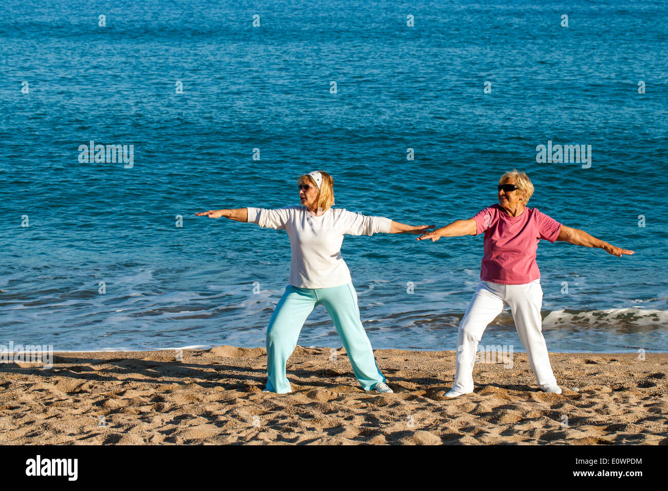 Seniors femmes faisant du yoga sur la plage. Banque D'Images