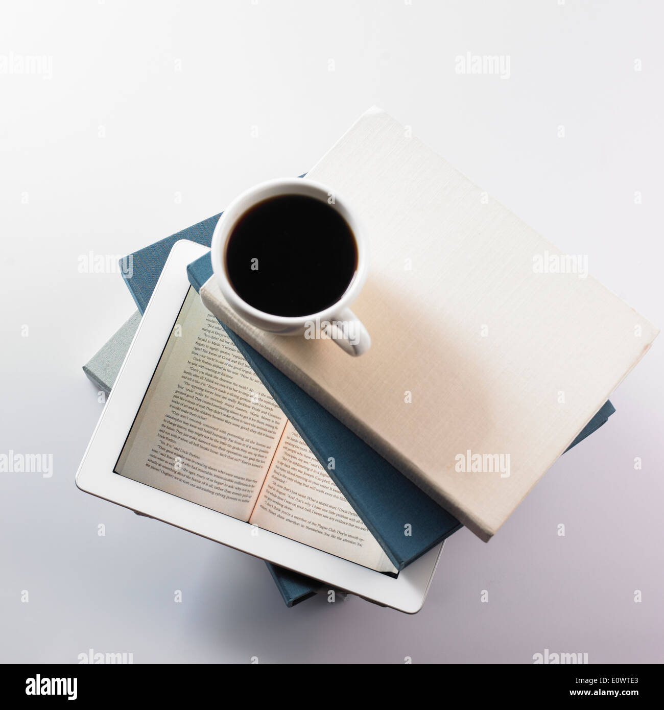 Une tasse de café sur le dessus d'une pile de livres et d'une tablette Banque D'Images