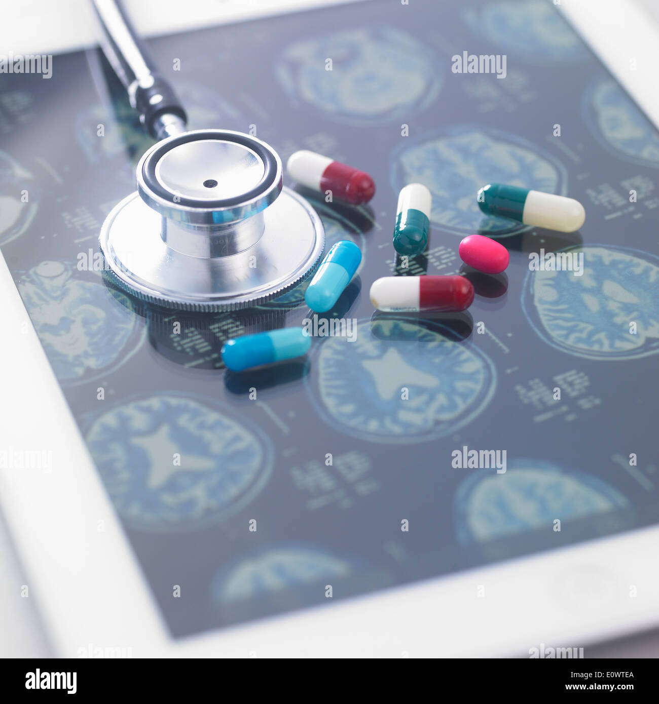 Un stéthoscope et des pilules sur le dessus d'une tablette avec des rayons x Banque D'Images