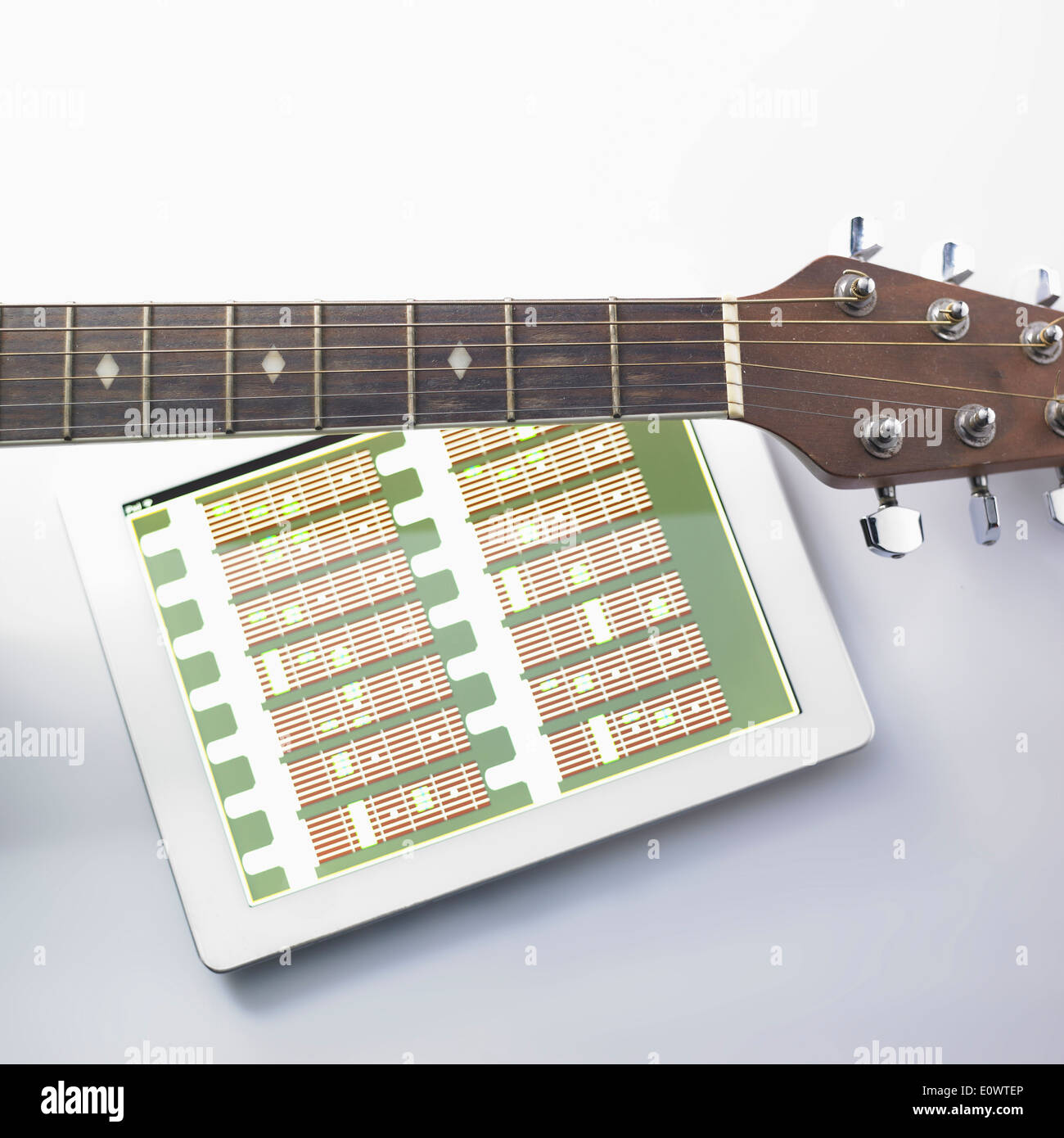 Une guitare à côté d'une tablette Banque D'Images