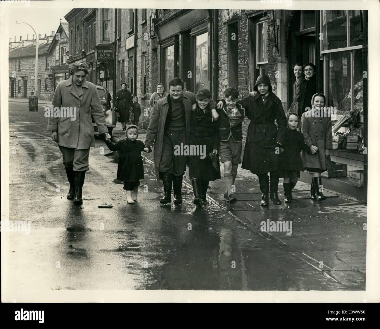 03 mars 1964 - inondations de Kendal. Des photos montrent que les mères ont escorté des enfants à l'école au-dessus des rues boueuses de Kendal à leur arrivée à l'école, ils l'ont trouvée fermée  à cause des dommages causés par les inondations. Banque D'Images