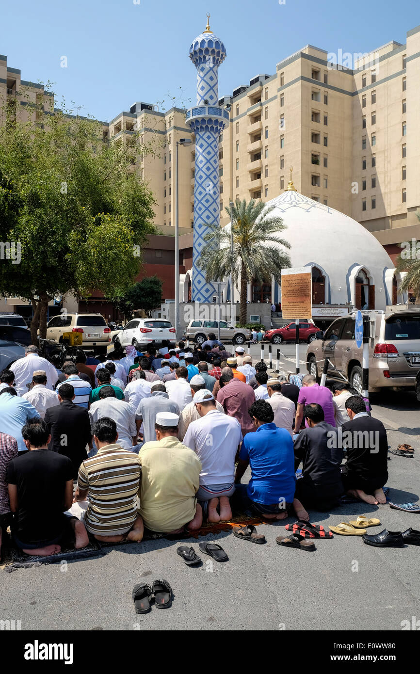 Beaucoup d'hommes prier le vendredi à la mosquée de l'extérieur du centre commercial Burjuman à Dubaï Émirats Arabes Unis Banque D'Images