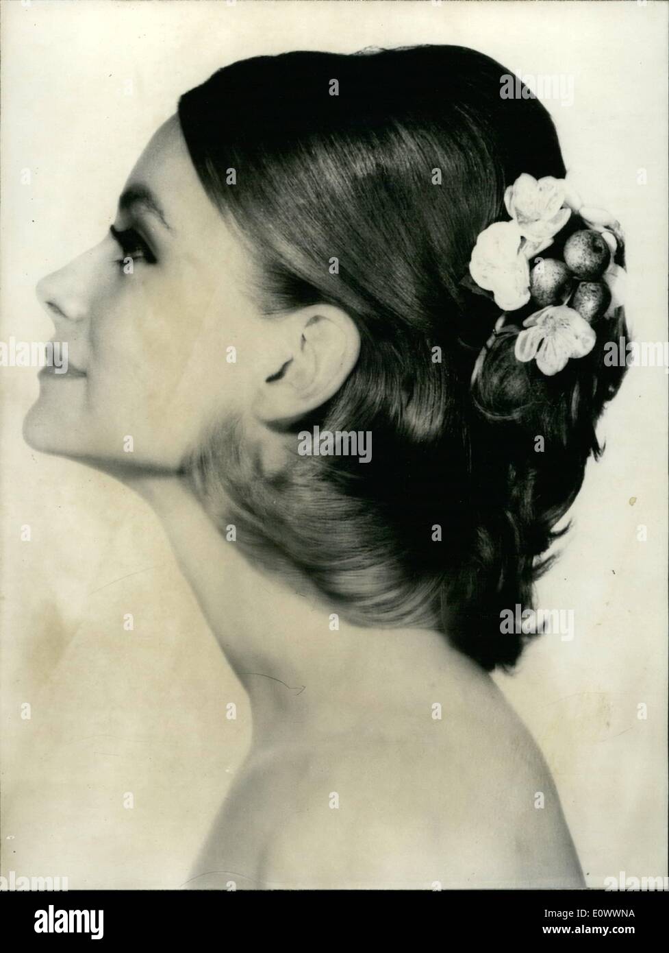Mai 05, 1964 - Flower Show sur vos cheveux. : coiffure Claude Simon de Charles du Ritz est pensée deffinetely printemps et l'été. Il a créé une nouvelle coiffure simple qui peut-être le coup de ces beaux jours. Il lui donna le nom ''Floralies''. Photo montre un joli modèle présente ''Floralies'' les cheveux sont épurées derrière et les serrures sont tirés sur le cou et détenues par une fleur bouguet apple. Banque D'Images