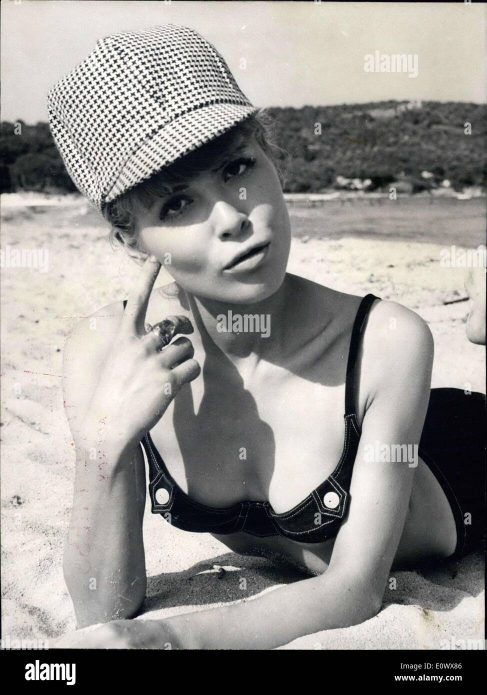 Juin 05, 1964 - Un code pin jusqu'à Saint Tropez ; la route de la gloire ne peut passer par Saint Tropez, la plage à la mode, pour joli starlet Pradine Berengere. Jusqu'à maintenant, elle avait été pour la plupart de l'actrice Catherine Deneuve, mais cette semaine, elle a commencé à travailler pour elle-même sur le film ''Le gendarme de Saint Tropez'' qui étoile Louis de Funes. En dépit de l'évolution des conditions météorologiques, le film est maintenant en cours et peut donner sa chance de Pradine, la starlette de 20 ans. Sous son chapeau de type Sherlock Holmes, Pradine Berenger tente d'obtenir un peu de bronzage sur la plage. Banque D'Images