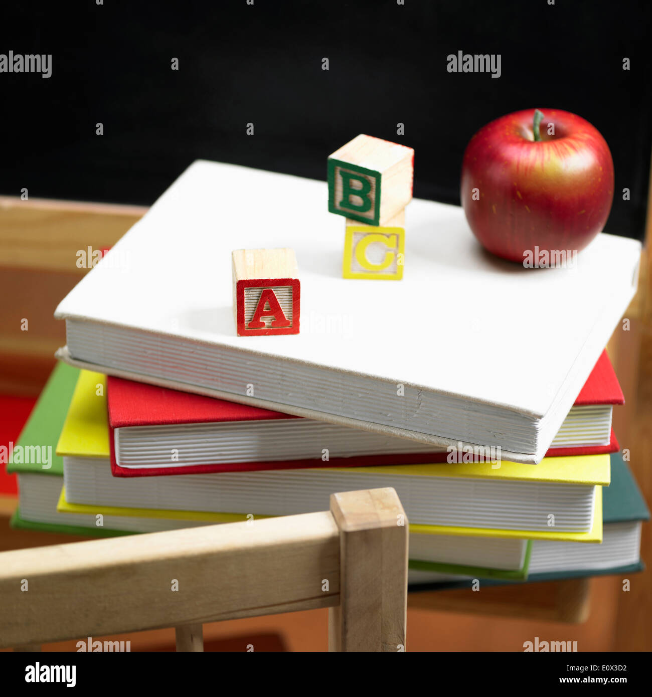 Une pile de livres et d'un apple en face d'un tableau Banque D'Images