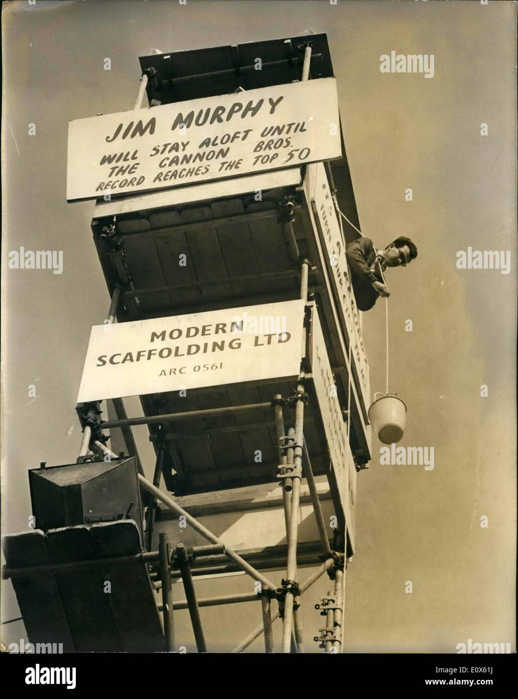 Mai 05, 1965 - s'accroupir sur le haut d'une tour : cascadeur Américain âgé de 25 ans, Jim Murphy, est accroupie sur une plate-forme d'arrêter un tour de 50 pieds, en dehors de la BBC studios TV à Alexandra Palace, et dit qu'il va y rester jusqu'à son enregistrement, ''tourner vos yeux à moi'', par le Cannon Brothers, hits le top 50. Il s'attend à être en altitude pendant environ un mois. Photo montre Jim Murphy photographié hauling up son petit-déjeuner dans un panier - forme le haut de la tour. Banque D'Images