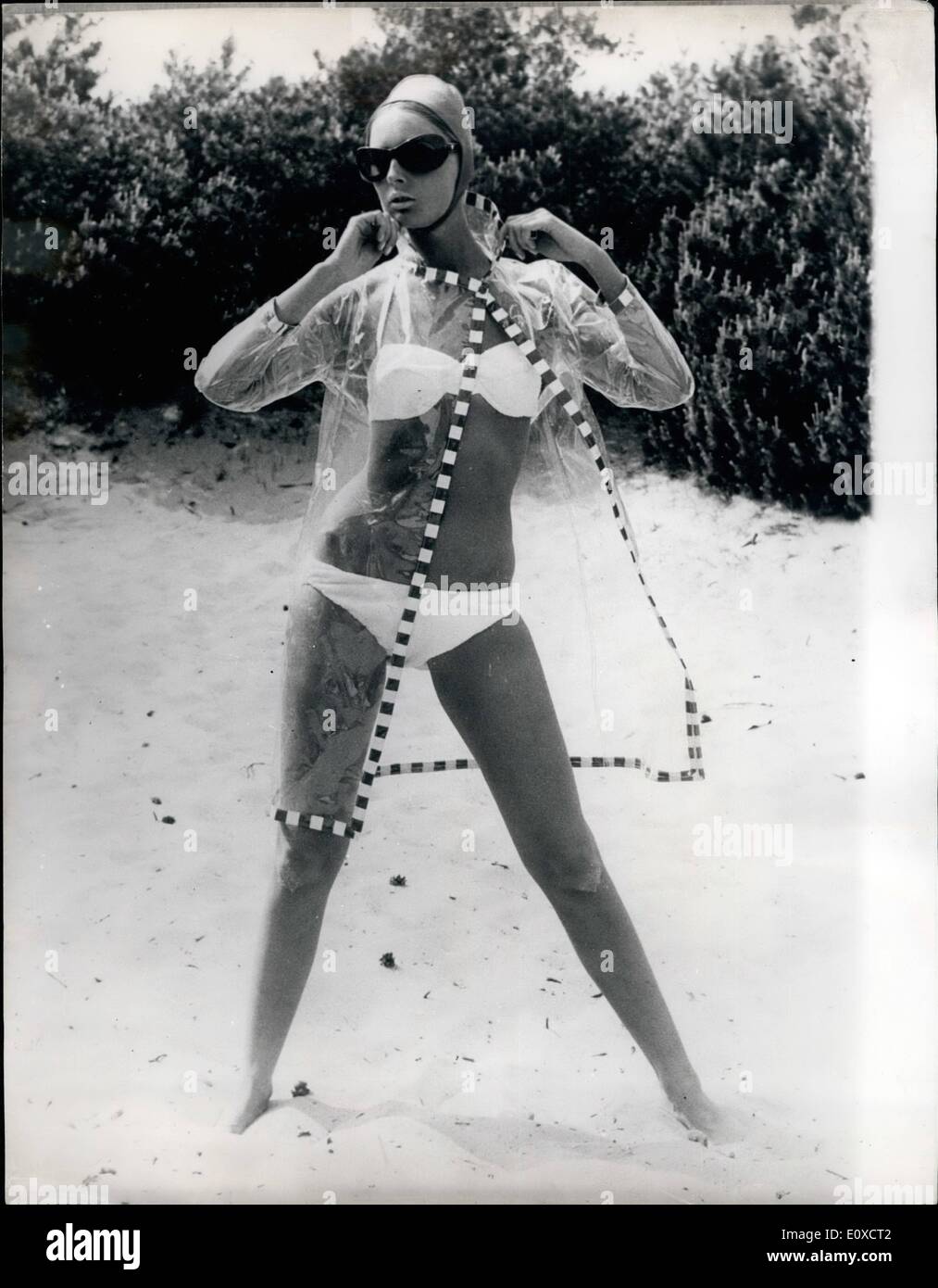 Juin 06, 1966 - AVIS OU NON UN IMPERMÉABLE POUR GARDER MA LADY'S BIKINI sèche. PHOTO MONTRE :- la dernière chose que du Danemark est ce raincat transparent en plastique qui peut être porté sur les jeunes femmes en bikini sur la plage. Banque D'Images