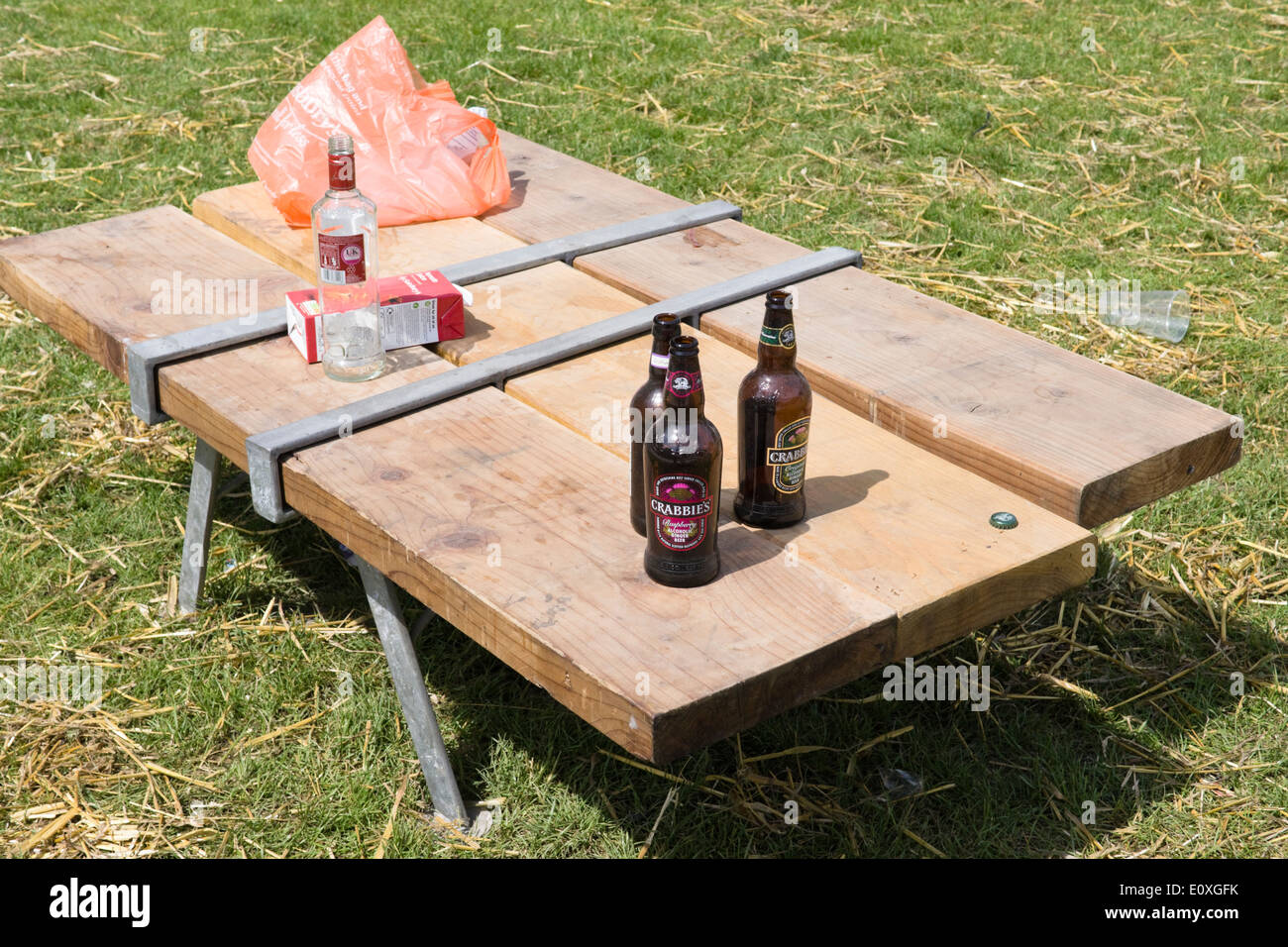 Table de pique-nique avec boissons en bouteilles vides Banque D'Images